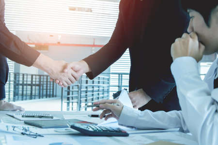 Asia Businessman together create a mutually beneficial business relationship. Economic graph on the tableの写真素材