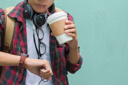 Education Concept. Man in Scottish shirt. Looking watch time and drinking hot coffee, Waiting...
