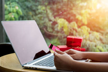 Close up ,Young asian woman typing laptop keyboard and holding credit card at coffee shop with online shopping or internet banking concept.Selective Focusの写真素材