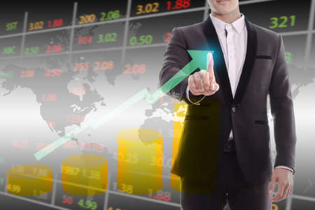 Businessman in black suit hand, touching stock market graph. Trading on stock market concept. ...