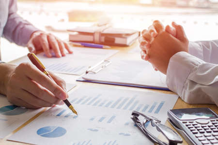 Business people team work meeting point to discuss the graph up and down of economy and work on...