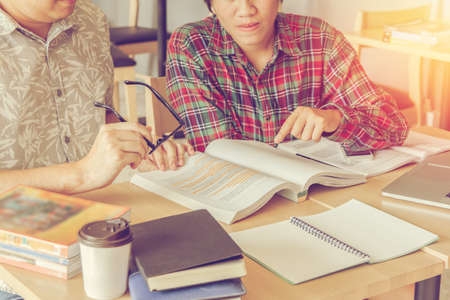 Asian young man,Homosexuality or woman sitting pointing studying examining. Tutor books with...