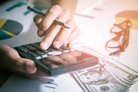 account working calculator, profit or graph economy on tables in office at home.

の写真素材