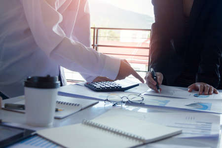 Business people team work meeting point to discuss the graph up and down of economy and work on tablet.の写真素材