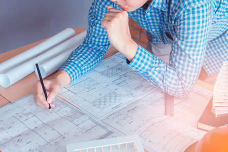 Concept architects,engineer holding pen pointing equipment architects On the desk with a blueprint...