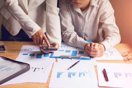 Asia Business using smartphone  meeting point to discuss, plan and chart the rise and fall of the...