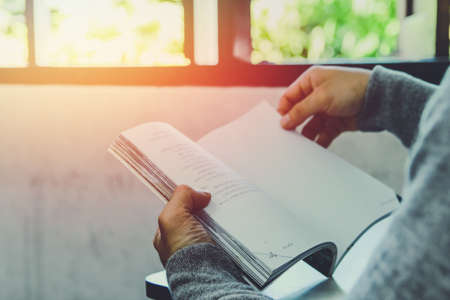 Man in black shirt and gray Hooded sweatshirt sitting  reading book test on table ,Copy space for...