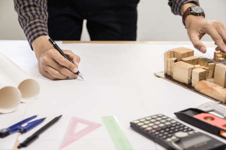 Concept architects,engineer holding pen pointing equipment architects On the desk with a blueprint...