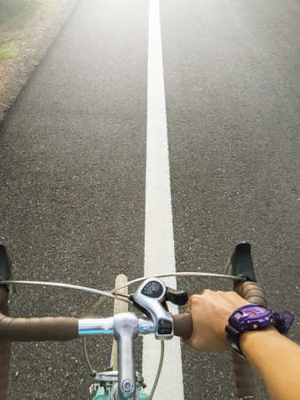 Handle Bicycle young man cyclist on road bike in sunset.の写真素材