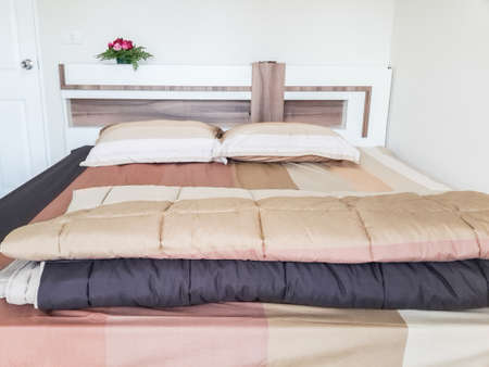 The bedroom is decorated in light colors with bedding brown with white furniture.の写真素材