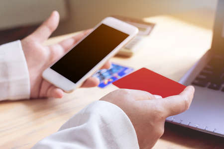 Close up ,Young asian woman typing mobile phone and holding credit card at home shop with online...