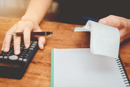 Young women of hand are calculating individual income tax to send information to government agencies. Using a calculator.の写真素材
