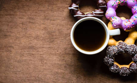 Top view, donut, chocolate, sweets and hot coffee or Americano. On wood table background.