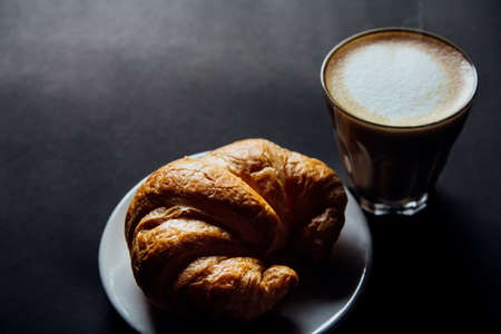 Croissant ,Latte art ,and moka pot with Roasted coffee on black background in the morning top viewの写真素材