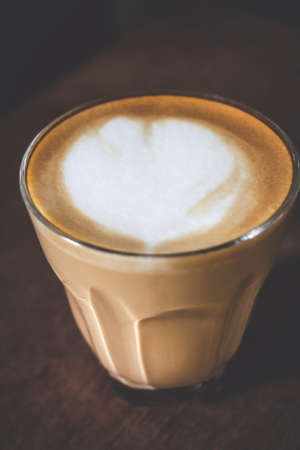 Latte art in cup on wood table in the morning at home, copy space for your textの写真素材