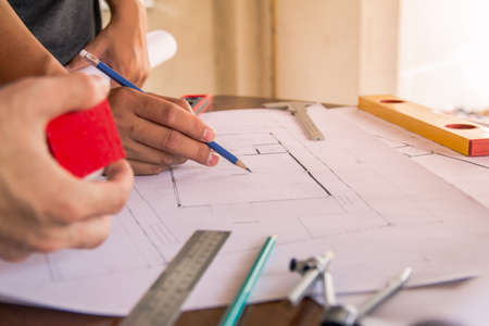 Concept architects,engineer holding pen pointing equipment architects On the desk with a blueprint...