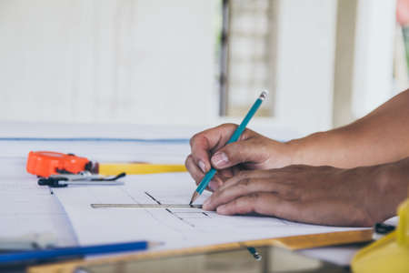 Concept architects,engineer holding pen pointing equipment architects On the desk with a blueprint...