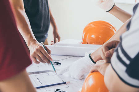 Construction workers and chiefs or architects are meeting on the interior design of the housing project on blueprint.の写真素材