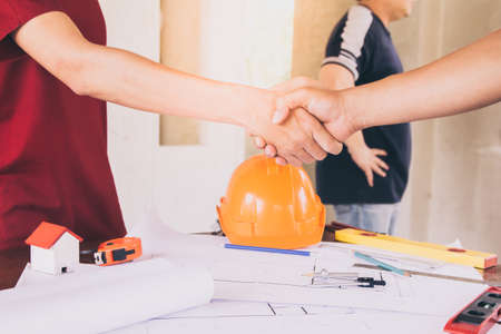 Asian engineer handshaking for teamwork in Interiors design and construction plan. Architect concept