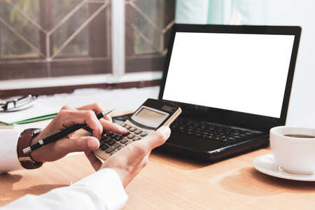 Asian man in white shirt holding pen writing a tax report lead to liquidation and using calculator...