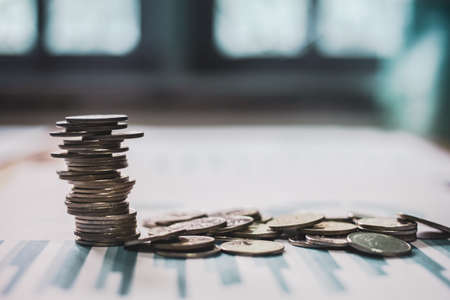 Silver coins placed in piles on desk with light sunset and   style filter photo vintage toneの写真素材