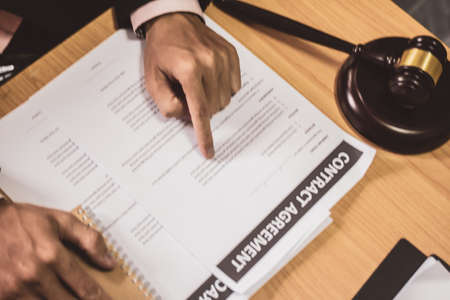 Hand businessman or lawyers sitting office Pointing contract papers on wood table. Law of advisor...