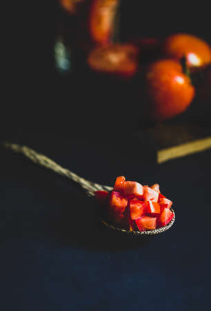 Fresh red tomato in wooden spoon healthy food and vegetable concept on black background
