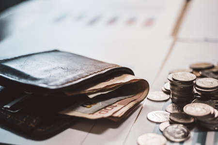 Silver coins and cash placed in piles on desk with light sunset . style filter photo vintage tone