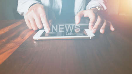 newsletter concept Hand of businessman checking message box on mobile phone with Vintage tone filterの写真素材