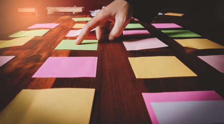 Start up. Business man in black suit meeting at home office and using notes  share design planning brainstorming idea on desktop wood table.の写真素材