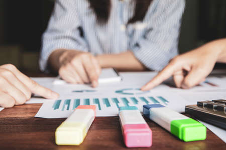 Start up business. people holding pen ,Team work meeting point to discuss the graph up and down of economy and work on table.Selective Focusの写真素材