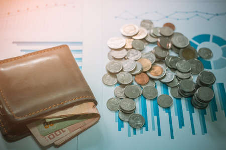 Silver coins and wallet on desk with light sunset style filter photoの写真素材