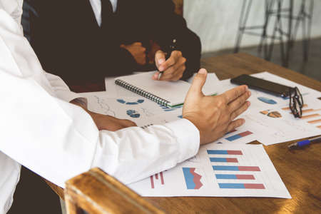 Start up business. people team work meeting point to discuss the graph up and down of economy and...