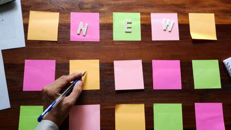 New. Business man in black suit meeting at home office and using notes paper share design planning. brainstorming brainstorm idea on desktop wood tableの写真素材