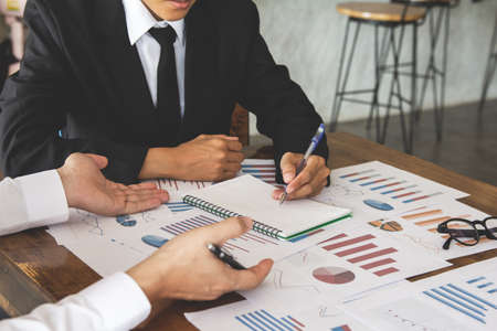 Start up business. people team work meeting point to discuss the graph up and down of economy and...
