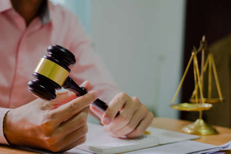 Holding Hammer law.Business man working on table. Lawyer Concepts .Selective Focus