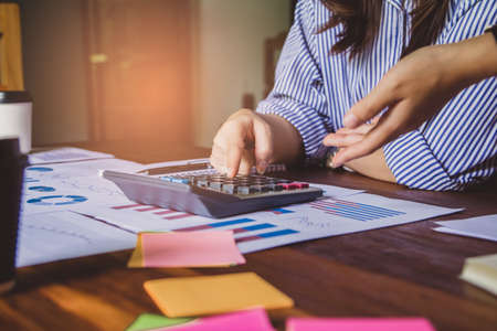 Group business woman hand using calculator Calculating bonus(Or other compensation) to employees to...