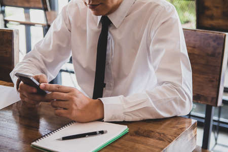 Business man of hands holding touching mobile phone with blank copy space for your text message in...