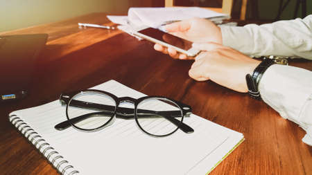 Glasses,Newsletter concept. Hand of businessman checking message box on mobile phone vintage tone filterの写真素材