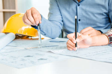 Concept architects, Engineer holding pen pointing equipment architects On the desk with a blueprint...