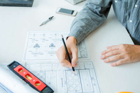 Concept architects, Engineer holding pen pointing equipment architects On the desk with a blueprint in the office.Selective Focusの写真素材