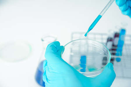 Medical science or male in laboratory room researcher performs tests of  dropper with blue liquid, Experimental Drug Treatment Chemicalsの写真素材