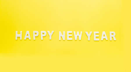 Sign and Symbol text of wooden Happy new Year  on bright yellow paper background.の写真素材
