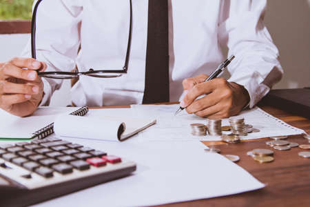 businessman Writing paper and using calculator Calculating bonus(Or other compensation) to employees...