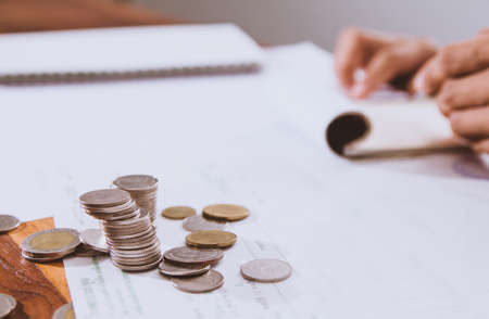 Silver coins placed in piles on desk with light sunset