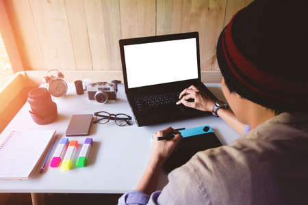 Asian man Interior designer of graphic design drawing on tablet and working laptop blank screen as...