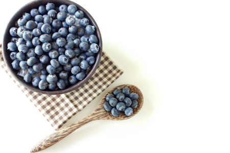 Fresh Blueberry in wooden cup on white table backgroundの写真素材
