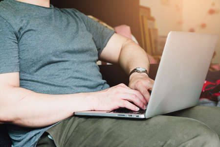 Young Business man sitting hands using laptop in bedroom on desk at home