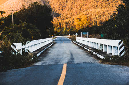 long road and  bridge to the mountains in Muang Lamphun Thailand .Landscape with  sunset sky and...
