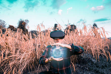 Asian man in gold rice field wearing glasses of glasses of virtual reality dissolving into pixels....